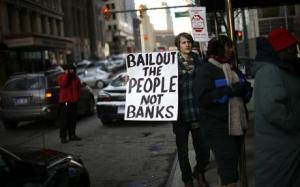 A man joins a protest organized by a group called "Moratorium Now" in front of the Bank of America building in downtown Detroit...A man holds a sign during a protest organized by a group called "Moratorium Now" in front of the Bank of America building in downtown Detroit, Michigan December 10, 2008. The protest is in support of Lorene Parker, a woman from Detroit who fell behind on her mortgage with Bank of America. Parker's home is scheduled for sheriff sale on Thursday.   REUTERS/Carlos Barria  (UNITED STATES)