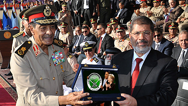 29/06/2012 WIRE: In this handout picture made available by the Egyptian presidency on June 30, 2012, (L to R) military council chief Field Marshal Hussein Tantawi (L), presents the "shield of the Armed Forces" the Egyptian military's highest honor to President Mohamed Morsi (R) during a ceremony at a military base in of Cairo.  Morsi was sworn in as Egypt's first freely elected civilian president on Saturday and formally received a transfer of power and pledge of support from the military, which has ruled since last year.  AFP PHOTO / HO ==RESTRICTED TO EDITORIAL USE - MANDATORY CREDIT "AFP PHOTO /EGYPTIAN PRESIDENCY " - NO MARKETING NO ADVERTISING CAMPAIGNS - DISTRIBUTED AS A SERVICE TO CLIENTS==