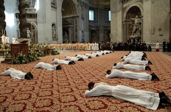 New priests lie in front of Pope Benedict XVI (L) during a mass for the ordination of new priests at St. Peter Basilica at the Vatican. AFP PHOTO / VINCENZO PINTO 