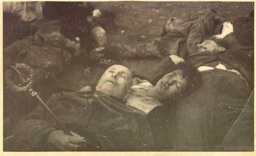 Mussolini's final rest on his Mistress's breast. The Leader is posed, holding his scepter and wearing a coat.  Condition of the bodies verifies this "pose" was taken prior to the 7 being hung up and beaten.