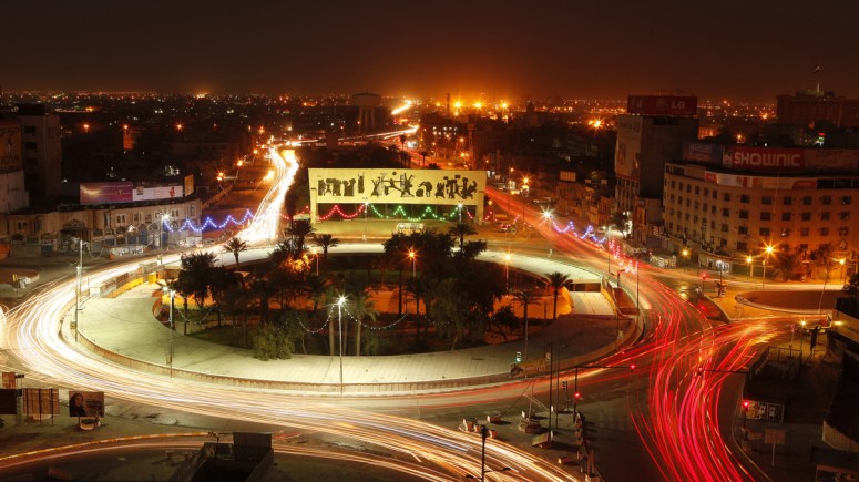 Traffic drives through Tahrir Square in central Baghdad on Wednesday. Ten years after the start of the war, bullet holes still mark buildings, and towers wrecked by U.S. missiles and tank shells have not been fully rebuilt.