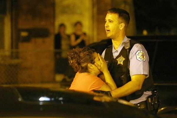 The mother of Ricardo Herrera is overcome with emotion after arriving at the scene June 15 of her son's fatal shooting on Ridgeway Avenue just north of 26th Street in Chicago's Little Village neighborhood. (Anthony Souffle, Chicago Tribune / June 16, 2013)