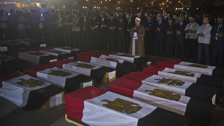 Egyptian army and security officers pray over coffins covered with the national flags at Almaza military Airbase in Cairo during a funeral for 25 policemen murdered by Obama's Muslim Brotherhood. There is also growing concern in Egypt that the same scenario is taking place in Syria to install them there by the banking cabal to do their bidding.