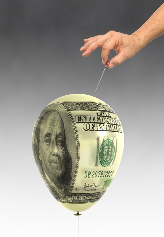Orchestrated balloon printed with a dollar bills about to be popped.
