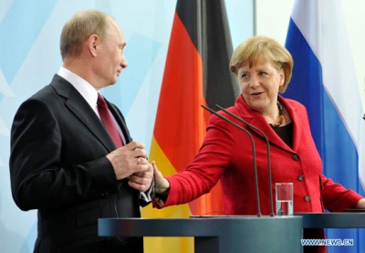 Russian President Vladimir Putin with German Chancellor Angela Merkel attend a press conference in Berlin in June