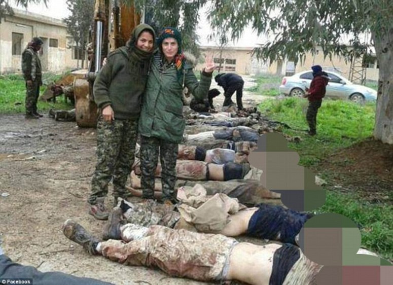 Sunni Kurd YPG soldiers smiling, in front of rows of dead ISIS bodies.